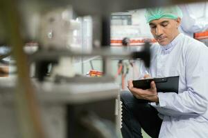 calidad supervisor o comida o bebidas técnico inspección acerca de condición controlar comida o bebidas antes de enviar producto a el cliente. producción líder volver a comprobar máquina y productividad foto