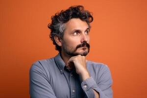 A man is being photographed on a solid background with a look of confusion on his face. photo