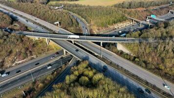 Fahrzeuge Fahren entlang ein beschäftigt Autobahn Austausch im das Vereinigtes Königreich Antenne Aussicht video