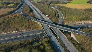 Fahrzeuge Fahren entlang ein beschäftigt Autobahn Austausch im das Vereinigtes Königreich Antenne Aussicht video