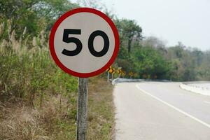 advertencia la carretera firmar con número 50 en rojo circulo a advertir límite velocidad ,hacer no conducir más que 50 kilómetros por hora en el rural la carretera en tailandia concepto , tráfico firmar velocidad límite 50 foto