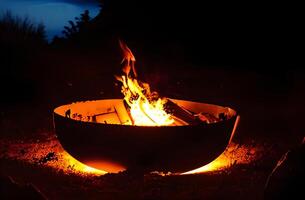 Fire plate with stack of woodglowing and burning wood in iron fire bowlbig bonfire in an old rusty fire bowl used for decoration a party copy space photo