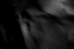 Dark black and gray blurred gradient and line of cloth or fabric background has a little abstract light. photo