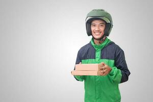 Portrait of Asian online courier driver wearing green jacket and helmet delivering package and box for customer. Isolated image on white background photo