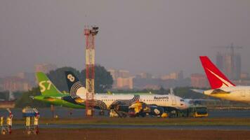 novosibirsk, ruso federación junio 10, 2020 - aviones son estacionado a tolmachevo aeropuerto en un caliente verano día. Aurora, s7, viento del norte aviones de pasajeros en el estacionamiento lote. video