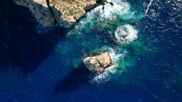 golven crashen tegen een klein eiland in de zee video