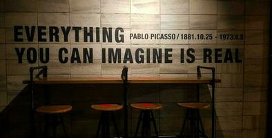 Jakarta, Indonesia in March 2019. One corner of a coffee shop that has a quote from Pablo Picasso, Everything you can imagine is real. photo