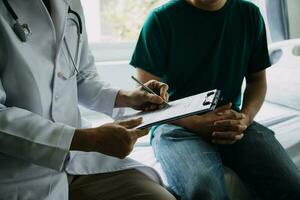 Doctor telling to patient woman the results of her medical tests. Doctor showing medical records to cancer patient in hospital ward. Senior doctor explaint the side effects of the intervention. photo