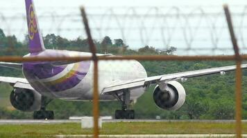 phuket, Tailandia diciembre 05, 2016 - fuselaje ancho pasajero avión boeing 777 de tailandés vías respiratorias partida, phuket aeropuerto, ver mediante el cerca. turismo y viaje concepto video