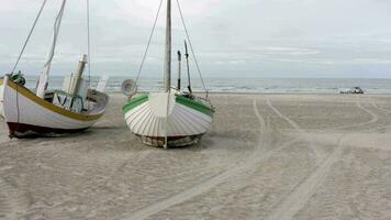 vieux pêche bateaux doublé en haut à terre sur à fond brin plage dans Danemark video