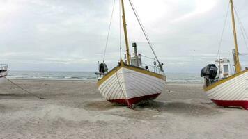gammal fiske båtar fodrad upp i land på thorup strå strand i Danmark video
