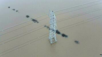 ein Elektrizität Pylon im tief Wasser im ein Hochwasser verursachen Leistung schneidet video