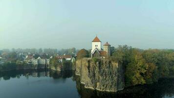 Igreja negligenciar uma pequeno lago em uma nebuloso manhã dentro Alemanha video