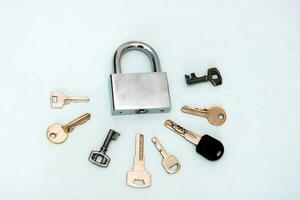 padlock with many keys on a light backgroundon photo