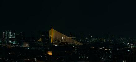 The suspension bridge at night, where the lights shine through is gold-colored. photo