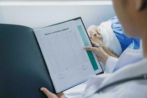 Doctor telling to patient woman the results of her medical tests. Doctor showing medical records to cancer patient in hospital ward. Senior doctor explaint the side effects of the intervention. photo