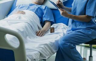 Doctor telling to patient woman the results of her medical tests. Doctor showing medical records to cancer patient in hospital ward. Senior doctor explaint the side effects of the intervention. photo