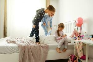 trillizos, amigos dos Niños y un niña son jugando en el para niños habitación. foto