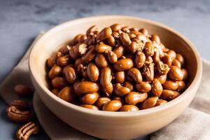 Roasted peanuts in white bowl on wooden background. Close up. photo