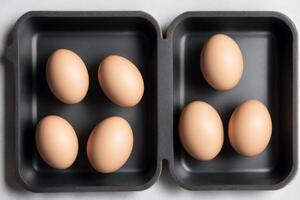 Eggs in a tray on a white background, top view. photo