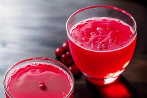 Cranberry juice in a glass on a wooden table, selective focus. Healthy food concept. photo