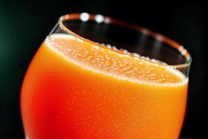 Carrot juice in a glass with fresh carrots on a dark background. close up. Healthy food concept. photo