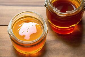 Honey in a glass jar on a wooden background. Selective focus. healthy food concept. photo