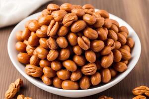 Roasted peanuts in white bowl on wooden background. Close up. photo