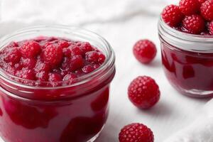 Raspberry jam in glass jars on a white background. Selective focus. photo