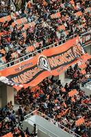 Crowds on Group of fans on the stadium Jakarta International Stadium. Selective focus on banner. Jakarta, Indonesia, August 1, 2022 photo