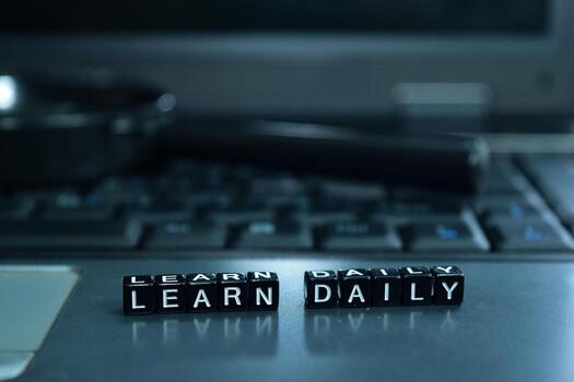 Learn Daily text wooden blocks in laptop background. Business and technology concept photo