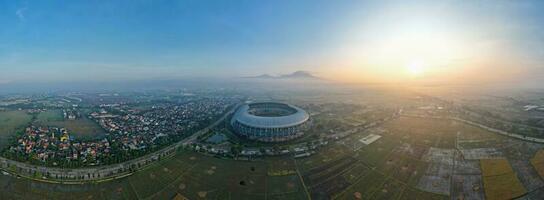 Aerial view of the Beautiful scenery Gelora Bandung Lautan Api Football or Soccer Stadium in the Morning with Blue Sky. Bandung, Indonesia, May 6, 2022 photo