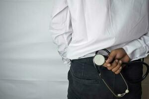 Physician or doctor holding stethoscope. Listening story patient concept. Selective focus in pants. Isolated on white background photo