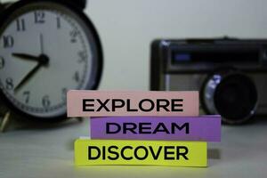Explore Dream Discover text on sticky notes isolated on desk background photo