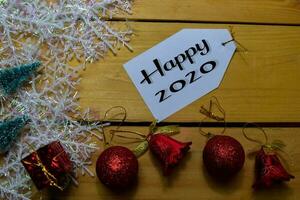 Happy 2020 write on label with wooden backgroud. Frame of Christmas Decoration. photo