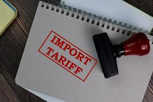 Red Handle Rubber Stamper and Import Tariff text isolated on the table. photo