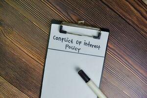 Conflict of Interest write on a paperwork isolated on Wooden Table. photo