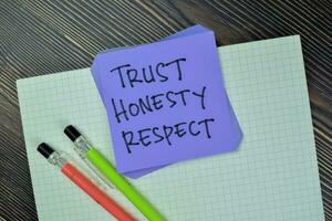 Concept of Trust, Honesty, Respect write on sticky notes isolated on Wooden Table. photo