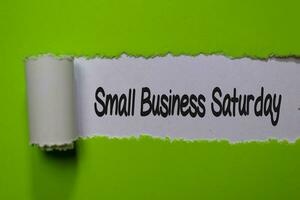 Small Business Saturday write on white and green torn paper photo