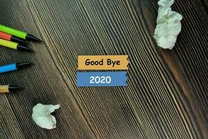 Good Bye 2020 write on sticky note and isolated on Wooden Table. New Year Concept photo