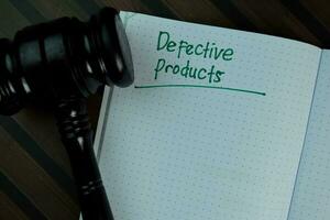 Defective Products write on a book isolated on Wooden Table. photo
