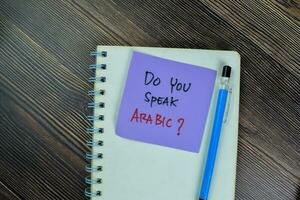 Concept of Do You Speak Arabic write on sticky notes isolated on Wooden Table. photo