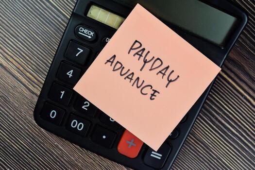 Concept of Payday Advance write on sticky notes isolated on Wooden Table. photo