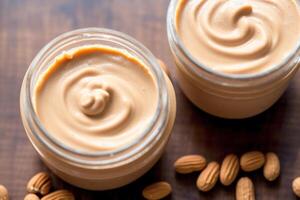 Peanut butter in a glass jar with peanuts on a wooden background. healthy food concept. photo