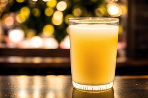 Glass of fresh mango juice on wooden table, closeup. Healthy food concept. photo