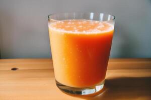 Glass of fresh mango juice on wooden table, closeup. Healthy food concept. photo