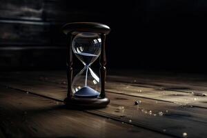 Hourglass on dark background, Time is running out. photo