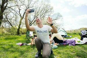 papá carreras un vlog. contento joven familia teniendo divertido y disfrutando al aire libre en picnic cobija a jardín primavera parque, relajación. foto