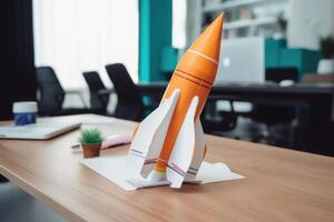 Successful startup concept. Launching rocket on office table. photo