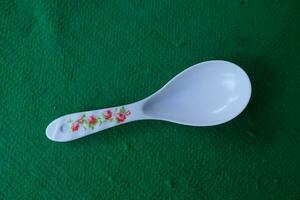 Photo of a white spoon with a green background